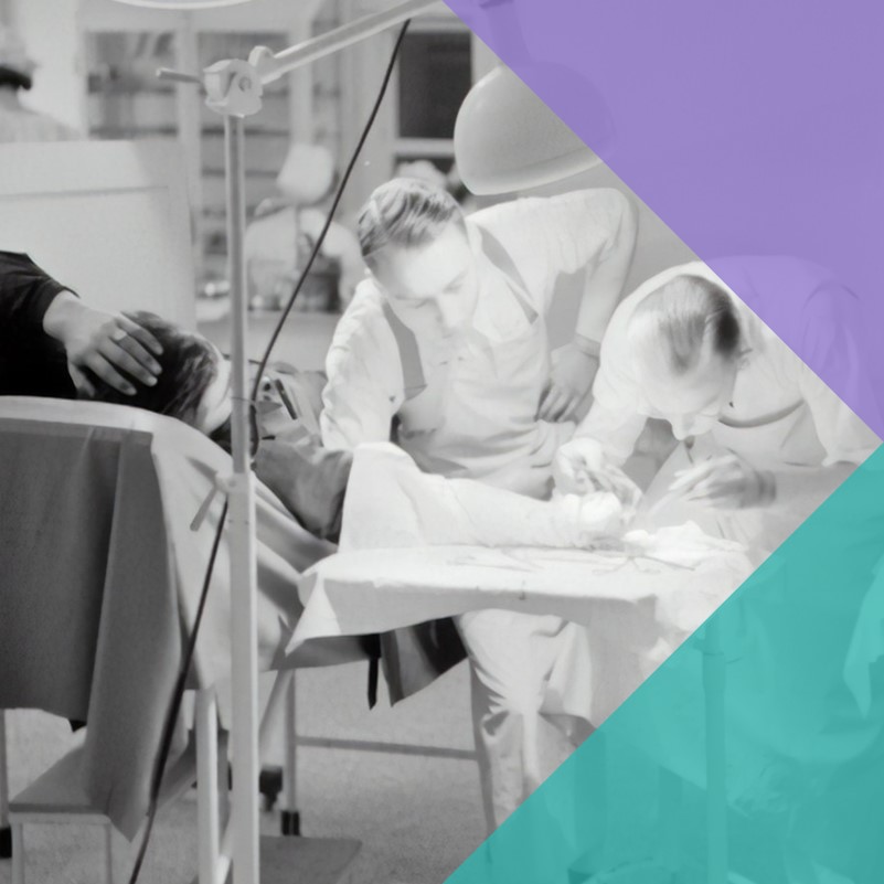 A black and white photograph of a hospital in the 1950s with a man having his arm examined by two doctors